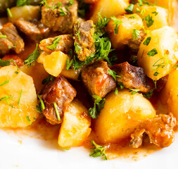dish of baked potatoes with beef stew with herbs