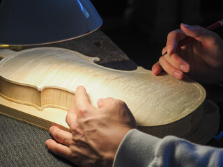 luthier working on a new violin in his workshop