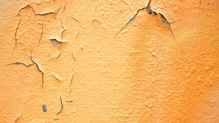 Orange wall with graffiti and cracks 