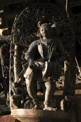 Obraz premium Stone Sculpture of Beautiful Female (Madanikas) with selective focus, 12th century Hindu temple, Ancient stone art and sculptures in each pillars, Chennakeshava Temple, Belur, Karnataka, India.
