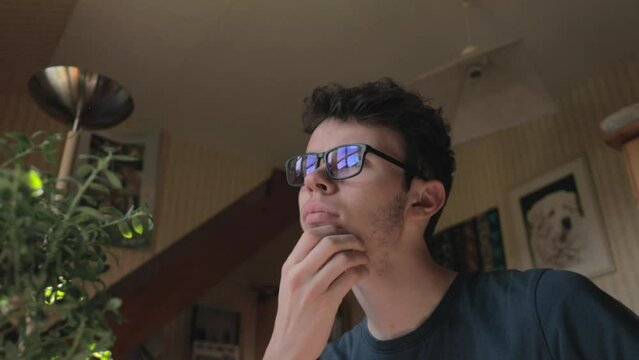 Jeune homme avec des lunettes r&eacute;fl&eacute;chissant &agrave; une d&eacute;cision, gros plan - Young caucasian man with glasses thinking about a decision, close up