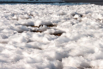 A bright texture of a melting snow during a sunrise and a windy weather