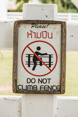 Signs symbolize banned climbing in a garden.