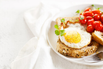 Healthy breakfast toast with fried egg and tomatoes.