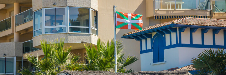 Ikurrina flag, a Basque symbol and the official flag of the Basque Country Autonomous Community of Spain and France, waving in front of a house in Arcachon - obrazy, fototapety, plakaty