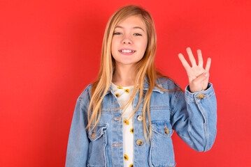 blonde little kid girl wearing denim jacket over red background showing and pointing up with...