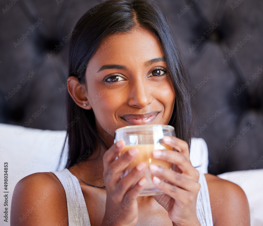 Sticker its definitely a good morning. shot of a young woman drinking a hot beverage while sitting on her be