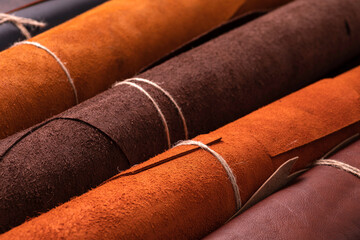 Rolls of natural brown red leather. Raw materials for manufacture of bags, shoes, clothing and accessories.