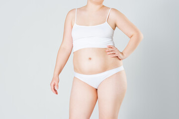 Fototapeta na wymiar Woman with fat abdomen, overweight female body on gray background