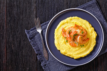 polenta with fried shrimps on plate, top view