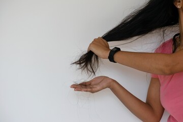 A woman showing excessive hair fall, hair loss, damage, dandruff, pollution, thin, grey hair in a...