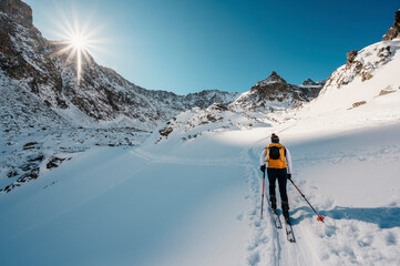 Mountaineer backcountry ski walking ski alpinist in the mountains. Ski touring in alpine landscape...