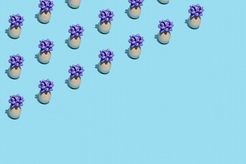 Seamless pattern made of Easter eggs with festive purple bow on blue background. Holiday concept. Copy space.