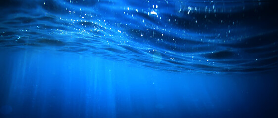 ocean underwater rays of light background, under blue water sunlight