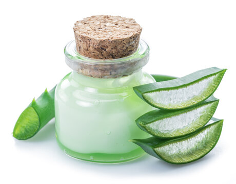 Aloe gel in the cosmetic jar and fresh aloe leaves on white background.
