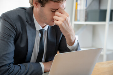 Young businessmen are tired and stressed from working by computer. Man has headache, eye strain, blurry vision, Migraine,office syndrome problem.