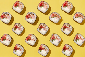 Sushi rolls pattern on yellow background.