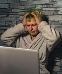 Mujer estresada por el teletrabajo con las manos en la cabeza , mujer de pelo verde desesperada por el trabajo remoto, trabajando con pijama desde casa