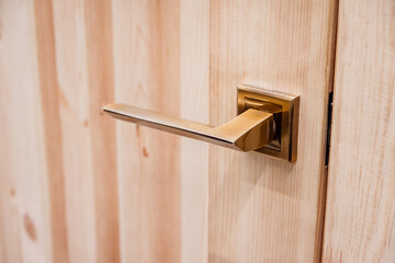 Door handle made of copper close-up. The design of a wooden interior or entrance door