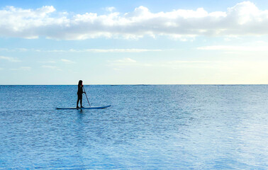 Young woman surfing alone in the ocean in Hawaii