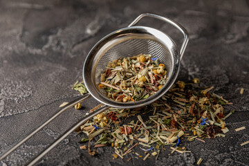 Herbal tea in a brewing strainer. Composition on dark textural background. view from above. Place for text.