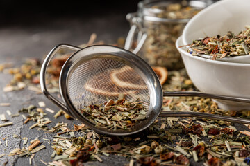 Herbal tea in a brewing strainer on a black textured background. Detox and tea for immunity. Herbal...
