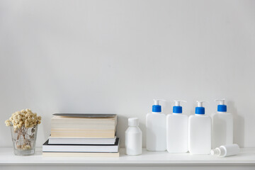 White bottles with a blue dispenser with shampoo, conditioner, cream and liquid soap, figurines...
