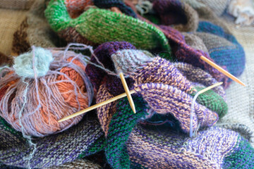 Close-up background image of a variegated knitted blanket with a colorful graphic design