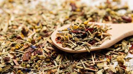 Wooden spoon with herbal tea leaves on tea background. side view. Detox and immune tea. Herbal...