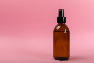 Skin care products in a glass jar. facial tonic. Composition on a pink background. Side view.Space for copy.
