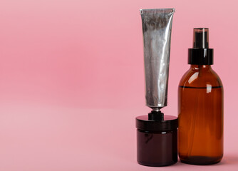 Cosmetic tubes on a pink background.Cream, serum, tonic, mask, scrub,washing gel.Face and hand care.MOCKUP. Side view.
