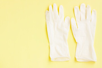 Obraz premium White latex protective gloves on yellow background