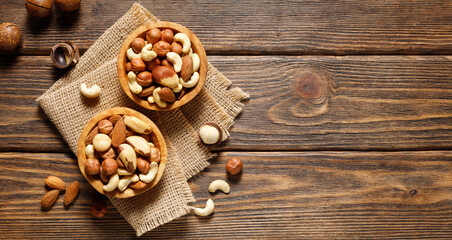 Various nuts in bowl - cashew, hazelnuts, almonds, brazilian nuts and macadamia on a wooden...