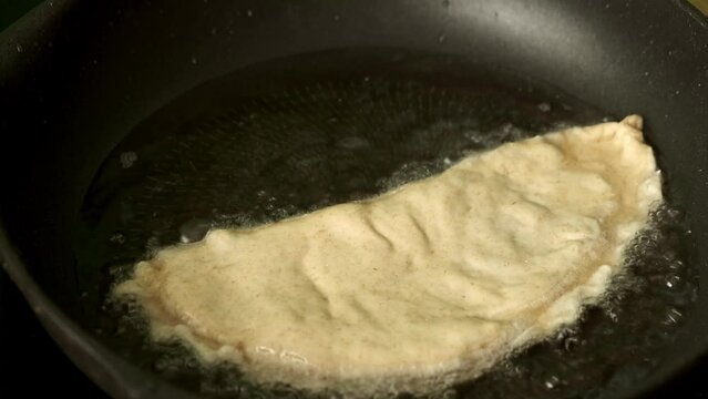 Process with fried homemade chebureks or qutab or calzone with minced meat and onion. Azerbaijani, Tatar, Caucasian, Greek cuisine.