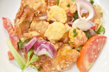 spicy batter slice fried egg with tomato and shallot Thai salad on plate