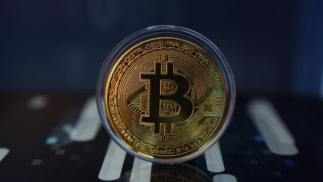 Cryptocurrency concept - bitcoin golden coin on digital display surface - peak into the digital decentralized currency technology. Lighting from screen changing fast.