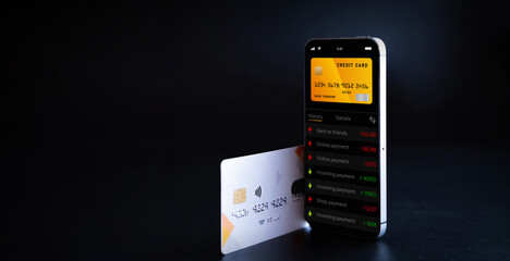 Internet based banking. Mobile phone with internet online bank app. Credit card on black background. Online wallet save money.