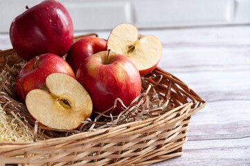 Fresh apples isolated in basket on wooden background under bright sunlight. Fresh natursl product. Harvest of apples. Little basket with harvest of fruit. Spring. Food. Close up