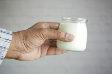 man hand holding glass of milk at early morning 