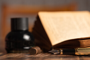 Naklejka premium Fountain pen, beautiful fountain pen in an environment with an old clock, old book, ink among others, selective focus.