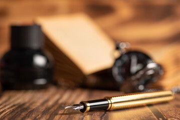 Fountain pen, beautiful fountain pen in an environment with an old clock, old book, ink among...