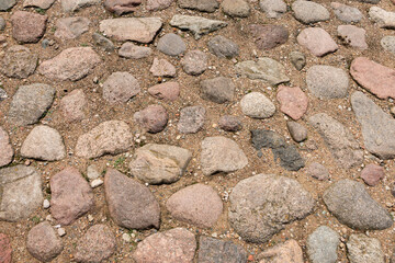 Cobblestone road in the sand. Fragment of paving stones. Background.Texture.