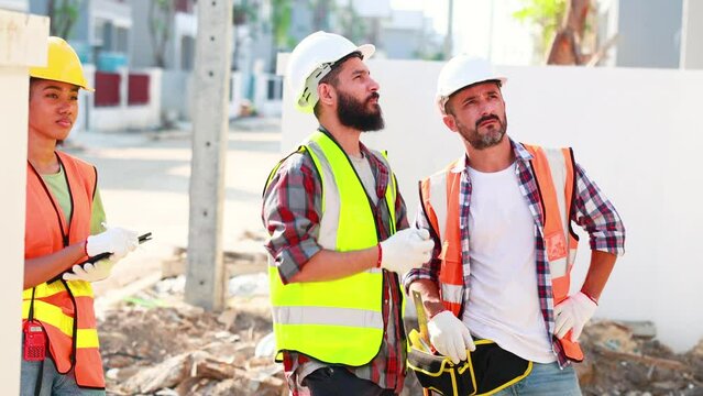 Professional Mechanical Engineer team wearing safety hard hat helmet working in  manufacturing factory under construction site.