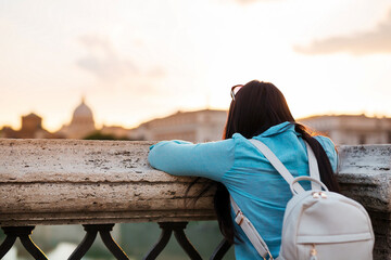 Young woman tourist watching San Pietro Basilica in Vatican city.