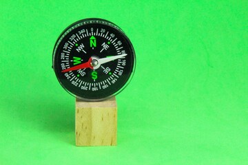 compass on a wooden cube with a green background