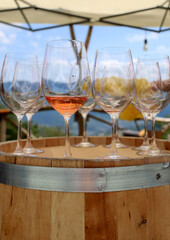 Glass of rose wine on a wooden barrel against the blue sky 