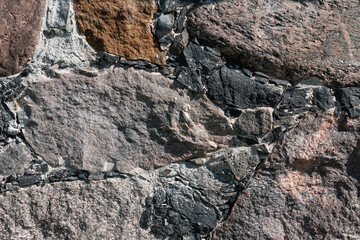Fragment of a stone wall from old boulders. Background. Texture from old cobblestone. Close-up.