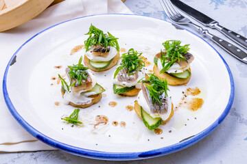 Herring with potatoes and onion with greens on plate