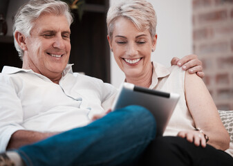 Is this what the kids are watching. Shot of a mature couple using a digital tablet at home on the sofa together.