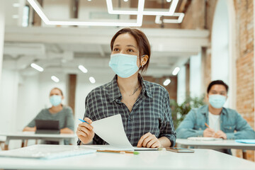 Female student attentively listening to teacher at university
